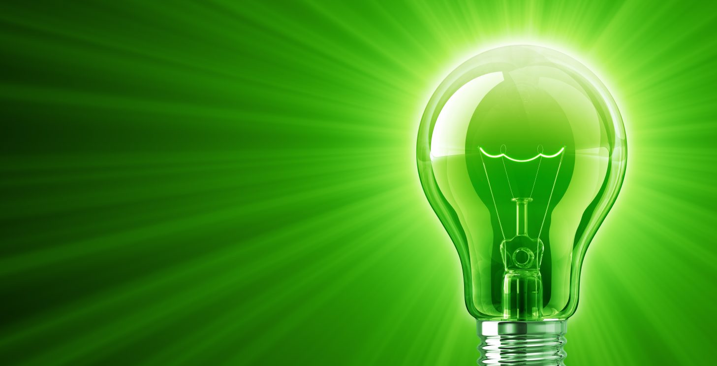 A lightbulb shining into a green background